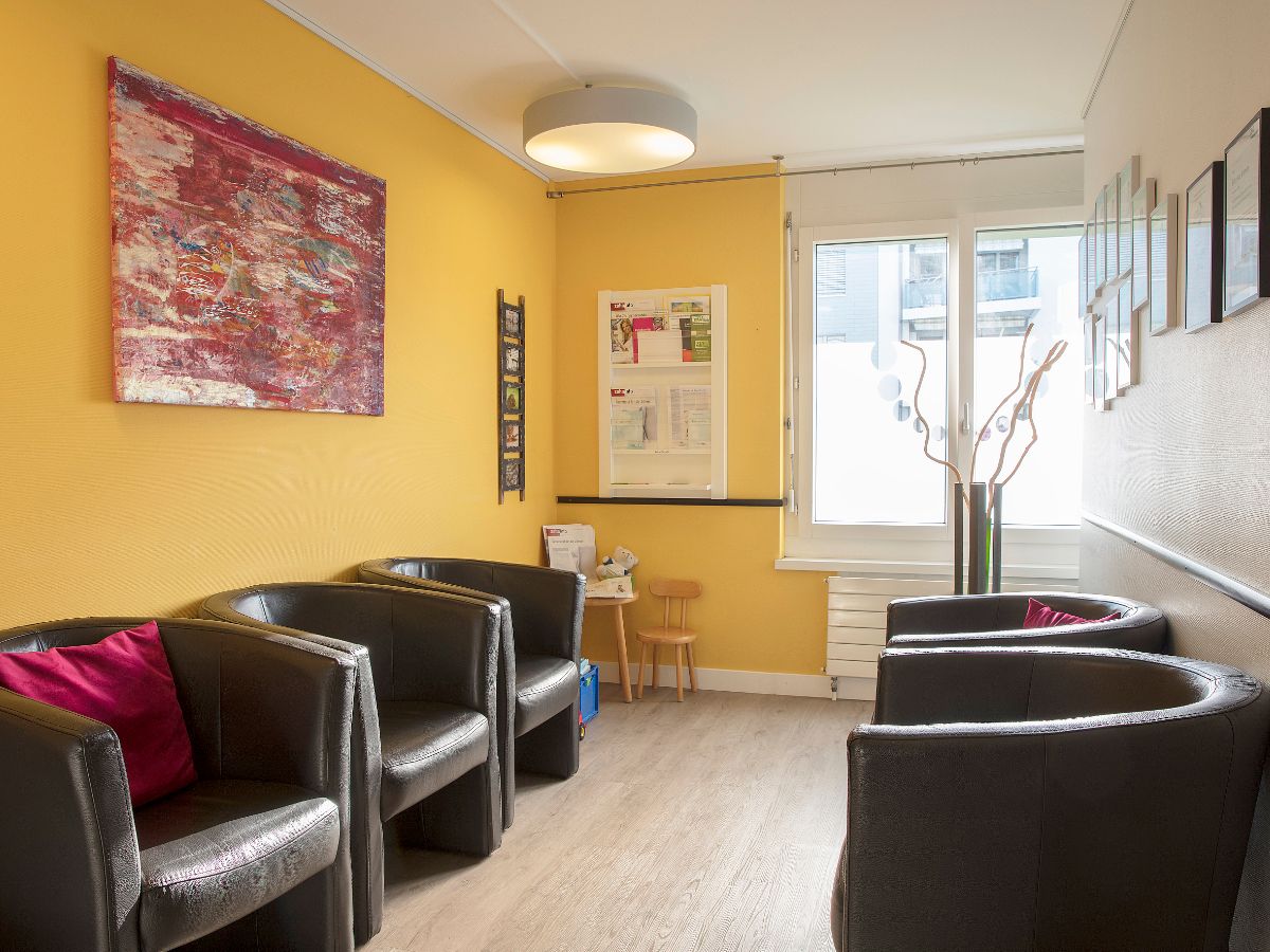 Wartebereich mit Ledersesseln und Kunst an der Wand